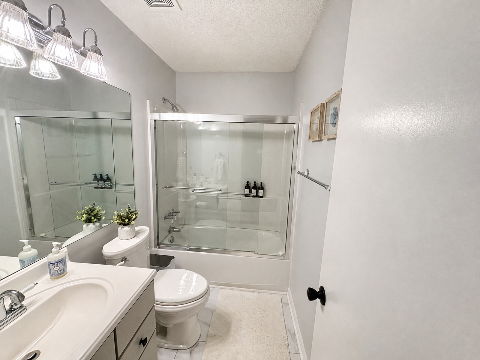 Full bathroom at Beaches Be Salty with vanity, toilet, and glass-enclosed tub and shower