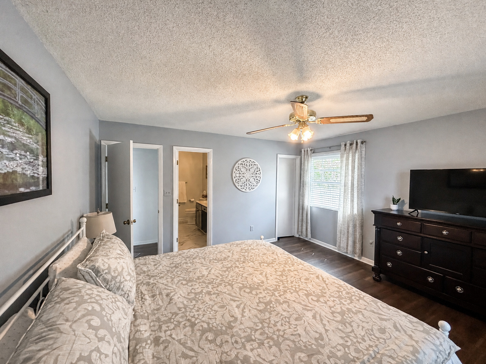Bedroom at Beaches Be Salty with en suite bathroom, TV, dresser, and ceiling fan