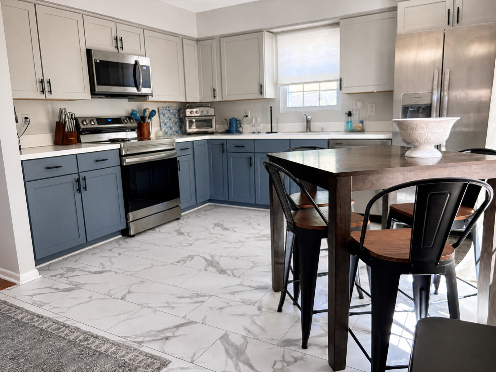 Kitchen and dining area at Beaches Be Salty with blue cabinets, stainless appliances, and table seating