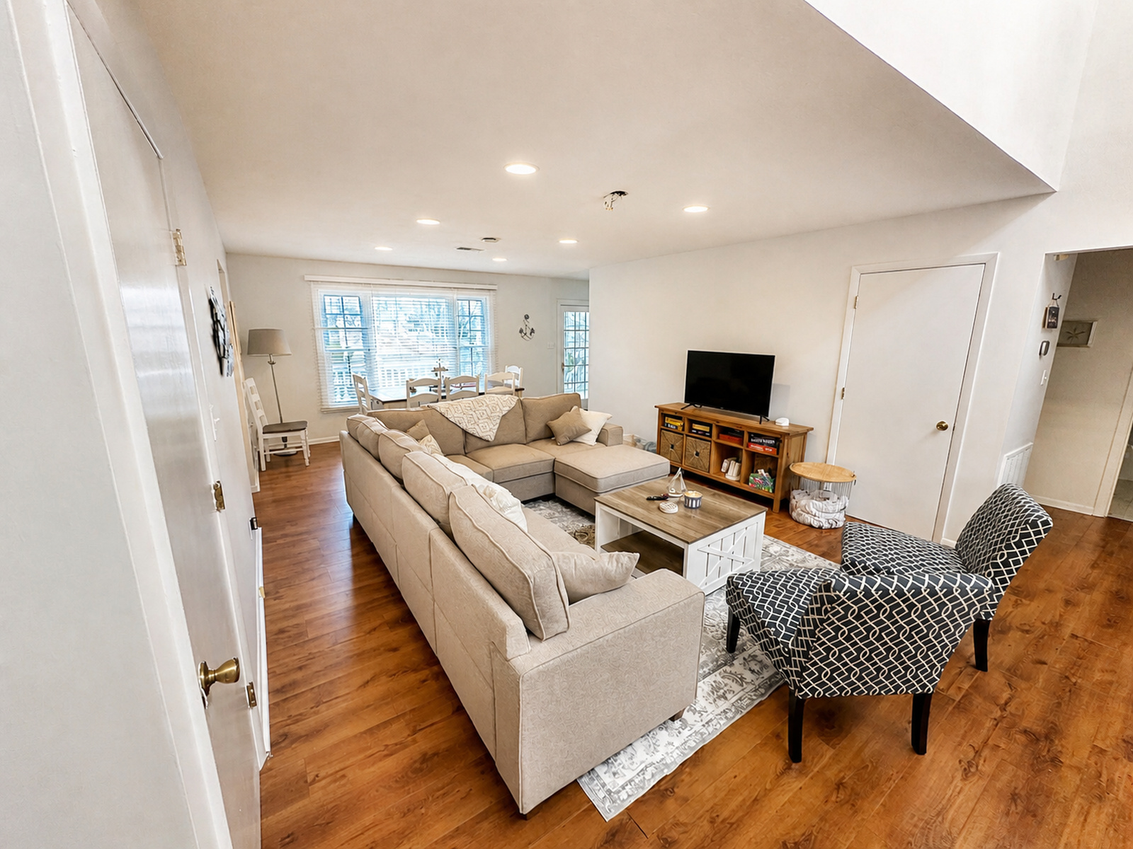 Main living room at Beaches Be Salty with sectional seating, patterned armchairs, and TV