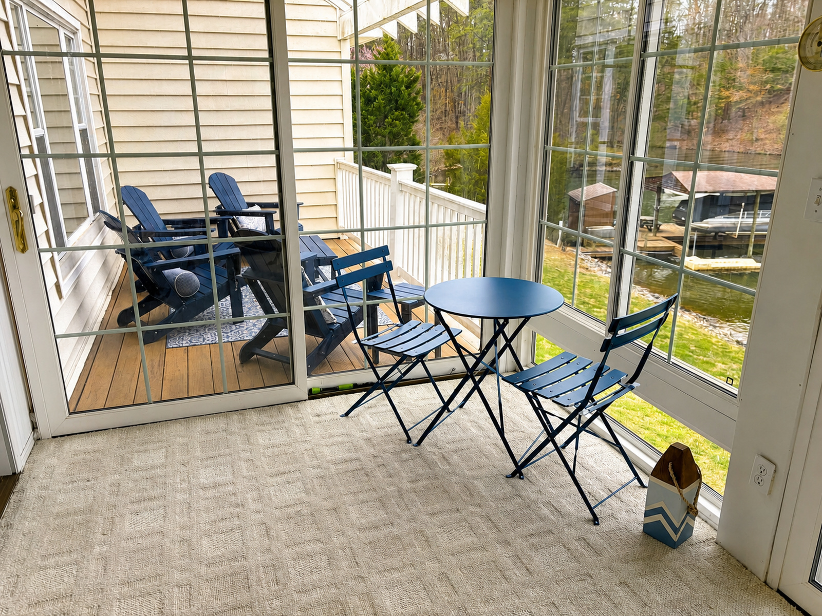 Sunporch dining area at Beaches Be Salty with bistro table and deck seating overlooking the lake