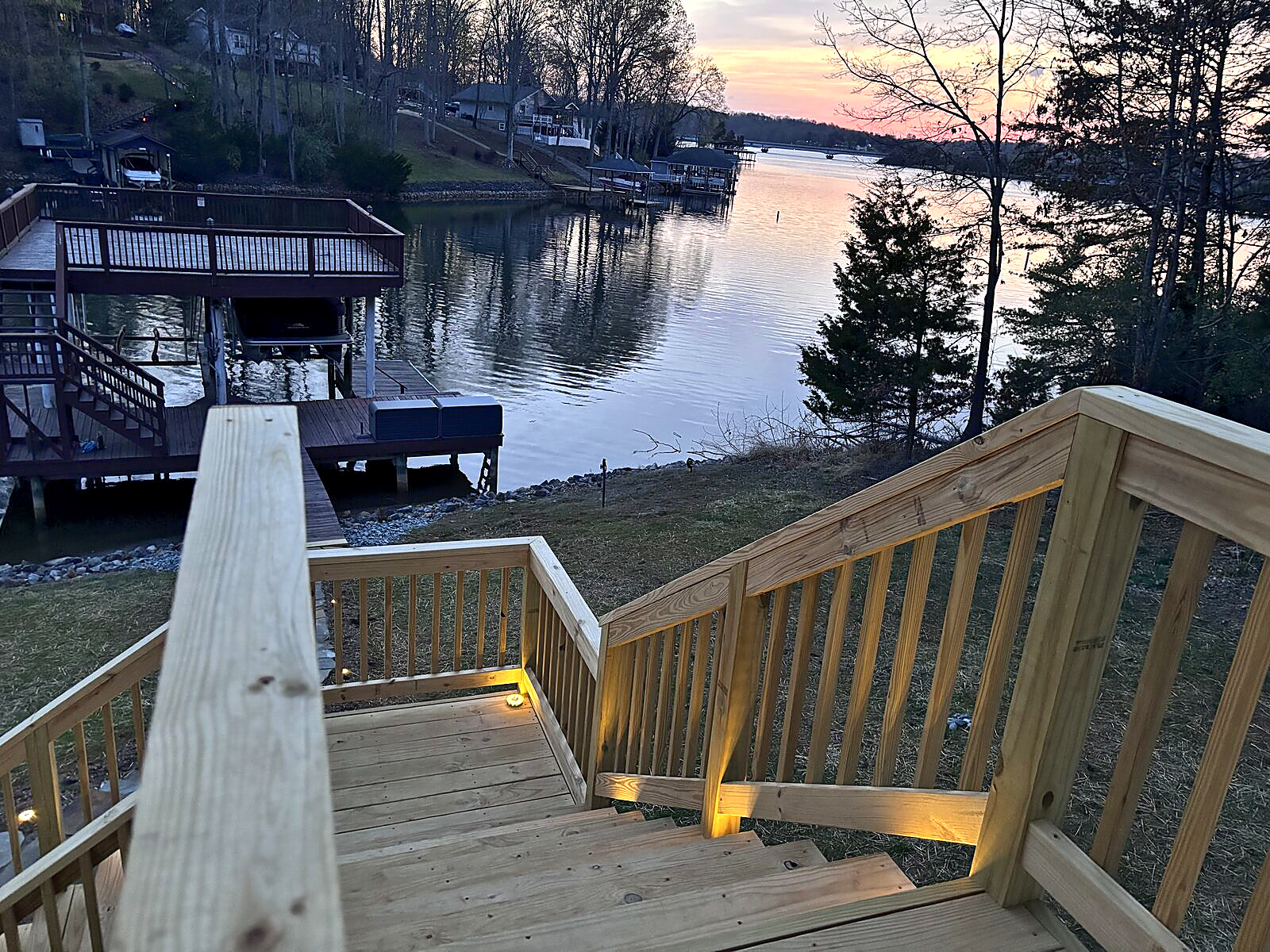Illuminated deck stairs leading to the private dock at Beaches Be Salty during sunset